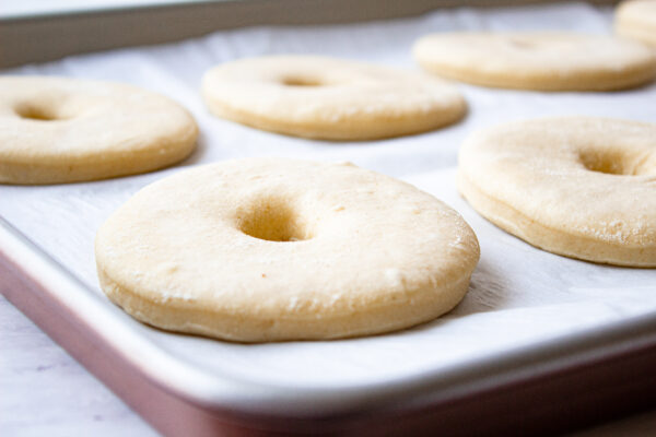 proofing the donuts on a baking sheet