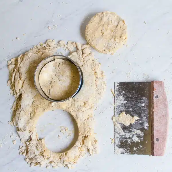 cut outs of einkorn biscuits and bench scraper