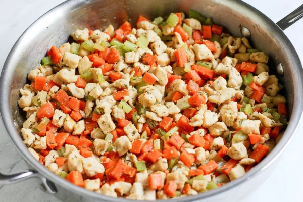 cooked diced chicken carrots and celery in pan
