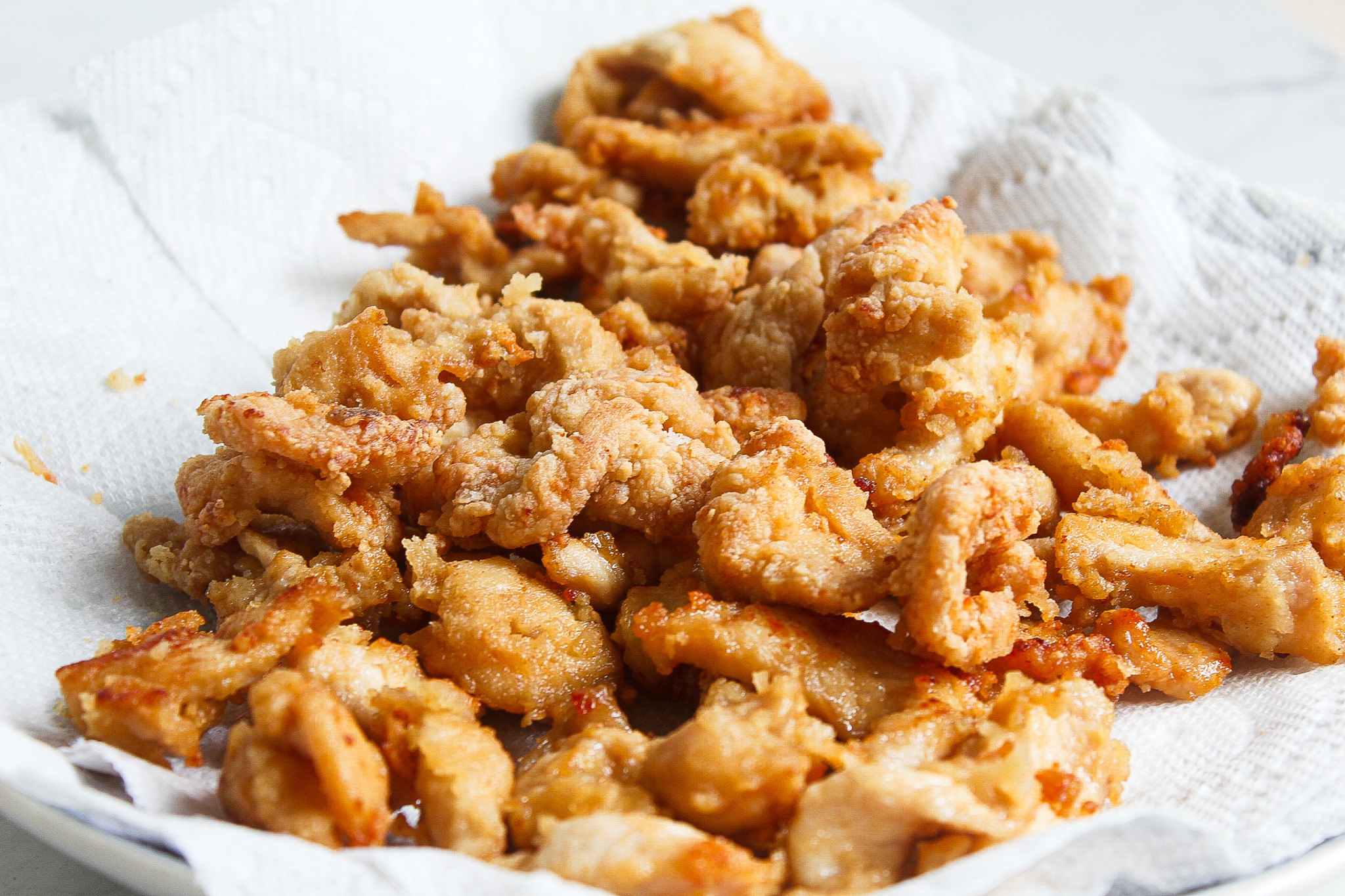 breaded chinese chicken on a plate with papertowels