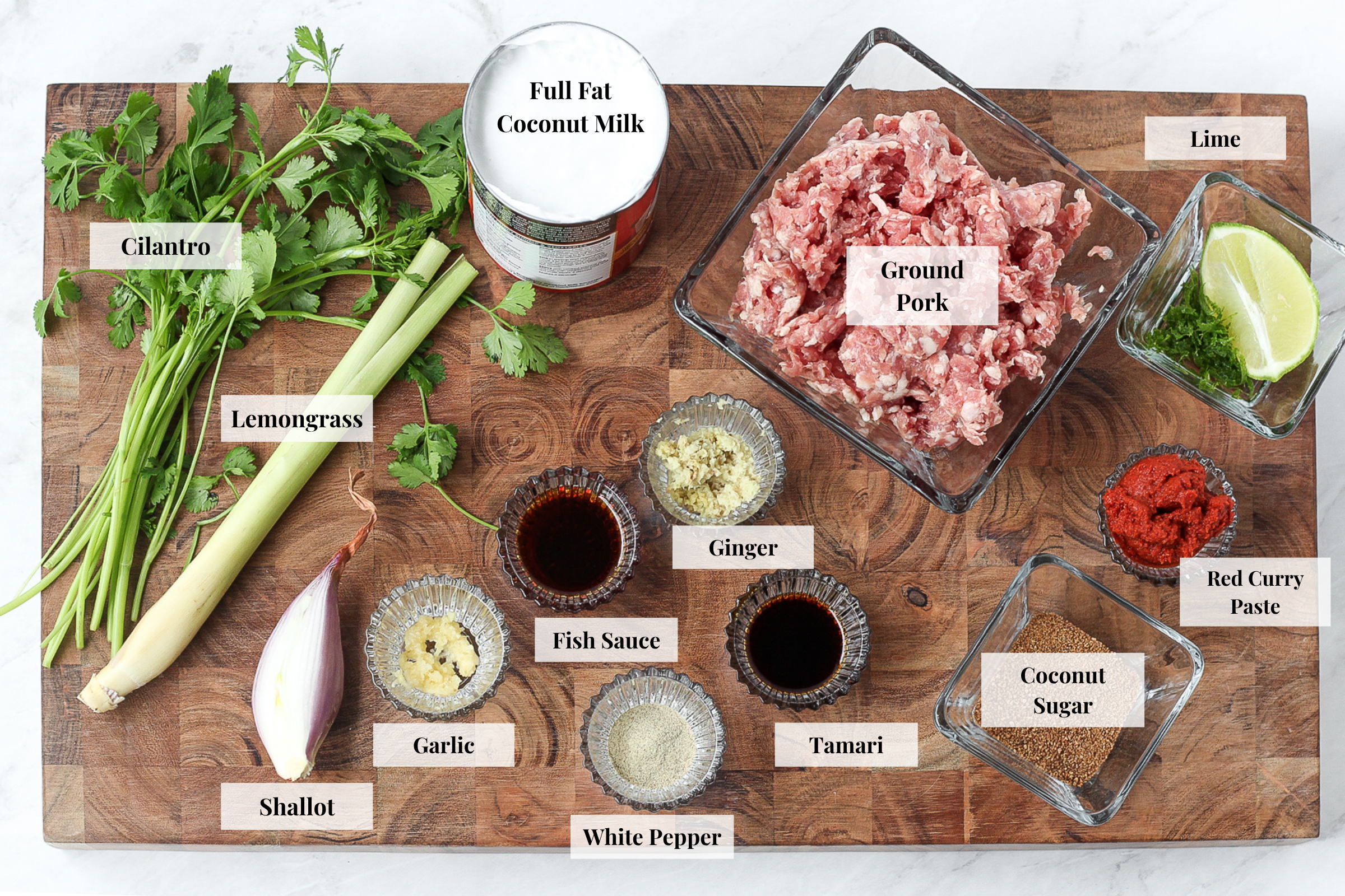 Overhead angle of ingredients for coconut curry meatballs recipe on a chopping board in glass bowls